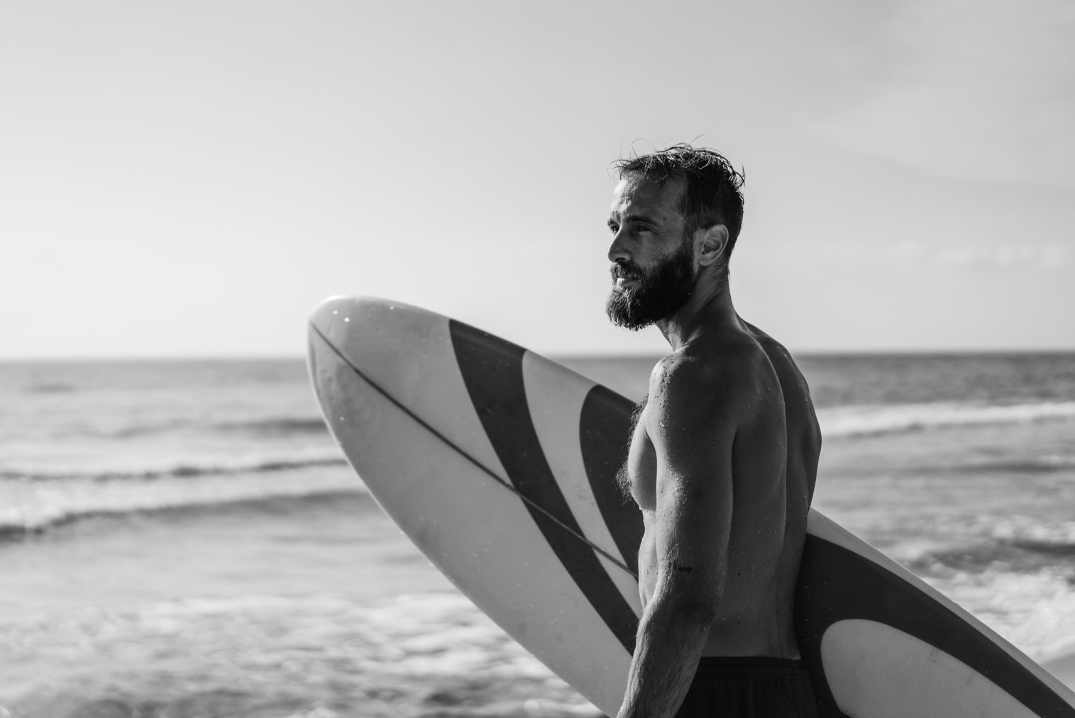 Man resting with surfboard near the ocean